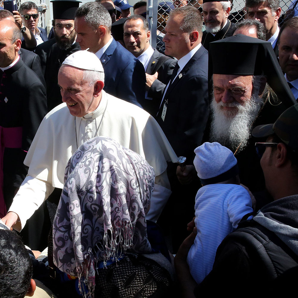 epa05261348 Pope Francis (C) arrives at a camp for refugees in Moria and greets refugee children, on Lesvos (Lesbos) island, Greece, 16 April 2016. Pope Francis visits the Greek island of Lesbos, accompanied by Ecumenical Patriarch Bartholomew, on 16 April, in a trip aimed at supporting refugees and drawing attention to the frontline of Europe's  migration crisis.  EPA/ORESTIS PANAGIOTOU